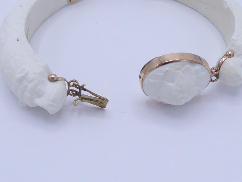 A 19th century carved white coral bangle, composed of two hinged sections terminating in a bear's - Image 3 of 3