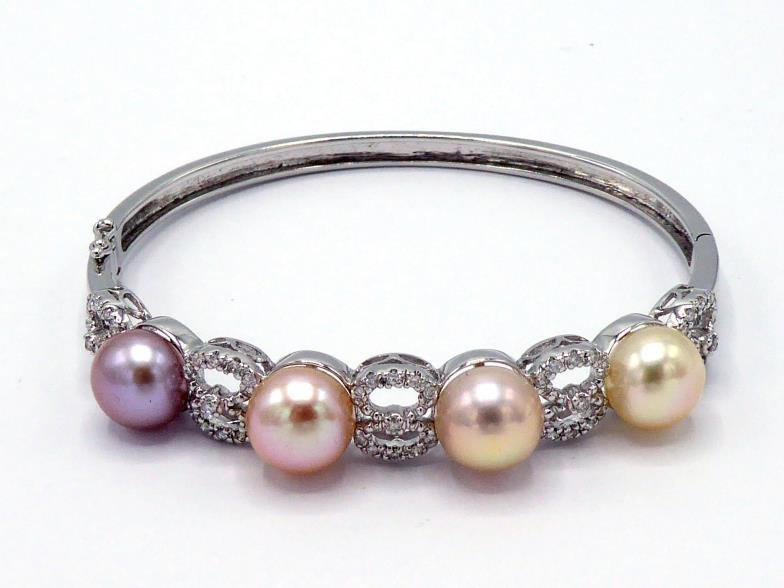 A cultured bouton pearl and diamond hinged bangle, the front set with four 9.5mm diameter pearls,