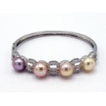 A cultured bouton pearl and diamond hinged bangle, the front set with four 9.5mm diameter pearls,