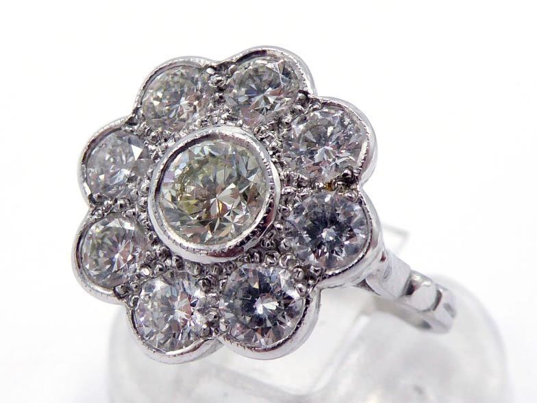 A diamond daisy cluster dress ring, the central collet set brilliant approx. 0.48 carat, in a