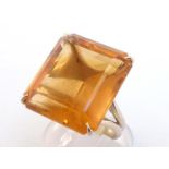 A citrine dress ring by H. Stern, the emerald cut stone 19 x 17mm, claw set above a yellow shank,
