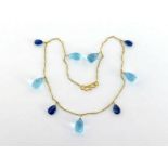 A sapphire and blue topaz necklace, the fine chain (tests 18 carat gold) set along its length with