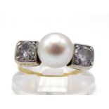 An Art Deco diamond and pearl (untested) ring, the 7.5mm central round pearl between two platinum