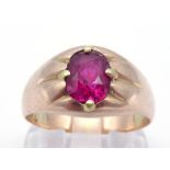 A gentleman's yellow metal (tests 14 carat gold) and synthetic ruby set ring, the oval cut stone