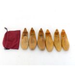 Three pairs of ladies folding wooden shoe trees together with a maroon linen shoe bag.