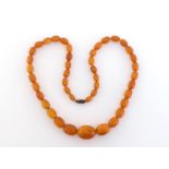 An amber bead necklace, composed of graduated oval beads, to a screw barrel clasp, 78cm long,