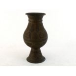 A 19th. century brass vase of near baluster shape, the body on wide tapering foot with spread base