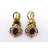 A pair of Italian diamond and garnet ear clips, the small oval cut stones rub over set, a small