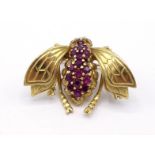 A yellow metal (tests 14 carat gold) and ruby brooch, modelled as a fly, the head, thorax and