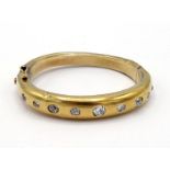A Victorian diamond bangle, gypsy set to the front with graduated mine cuts, the central stone