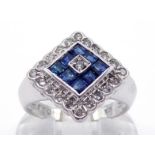 An 18 carat white gold, diamond and sapphire plaque ring, the square plaque with a central calibre