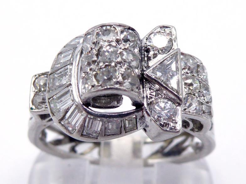 A mid 20th century diamond dress ring, the ornate buckle design set overall with single cuts and