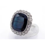 A French platinum, sapphire and diamond cluster ring, the large shallow sapphire approx. 11.68