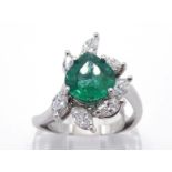 An emerald and diamond dress ring, the pear cut emerald 8.7 x 8mm, claw set above a spray of