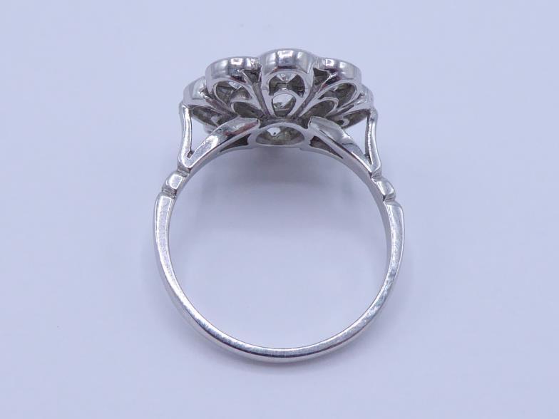 A diamond daisy cluster dress ring, the central collet set brilliant approx. 0.48 carat, in a - Image 2 of 3