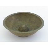 An Egyptian cast and turned brass bowl with raised centre, the inside and outside covered with