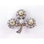 A late Victorian diamond clover brooch, circa 1890, each leaf centred on a fancy yellow mine cut