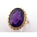 A 9 carat gold and amethyst dress ring, the large oval cut amethyst 14.7 x 11.5 x 6.8mm, shank fully
