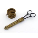 a pair of steel scissors in brass sheath embossed with classical imagery with a similar brass