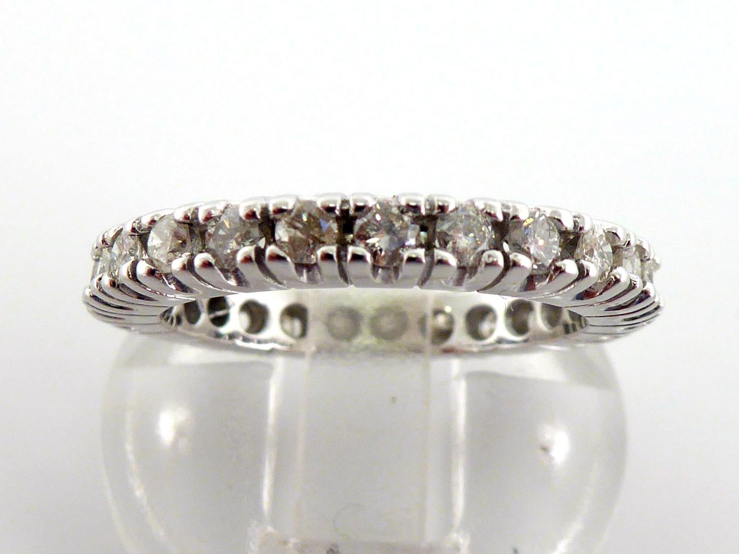 A diamond eternity ring, the band of brilliants totalling approx. 0.75 carat, the white mount