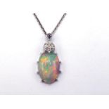 An opal and diamond pendant, the oval cabochon opal 14 x 8mm, with a pave set top, mounted in