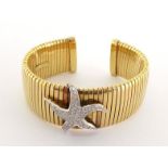 An Italian 18 carat gold and diamond cuff bangle, of ribbed design, set to the centre with a pave