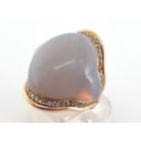 An 18 carat gold, opal and diamond ring, the central shaped opal cabochon descending into the