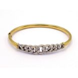 A diamond bangle, the central curb linked motif pave set overall with small brilliants, mounted in