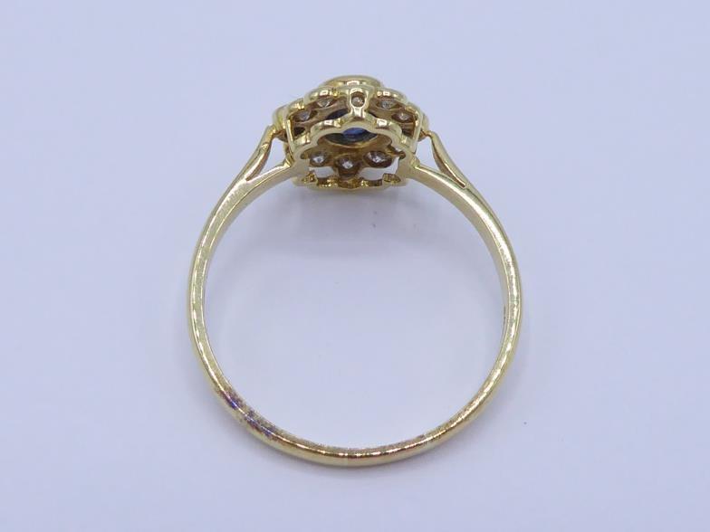 An 18 carat gold, sapphire and diamond cluster ring, the central oval cut sapphire 4 x 6 x 2.4mm, in - Image 2 of 3