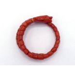 A Victorian carved coral 'serpent' bangle, composed of articulated scales on a wire, 4.4cm inner