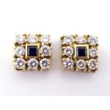 A pair of diamond and sapphire mounts, the square mounts set to the centre with a sapphire, in a