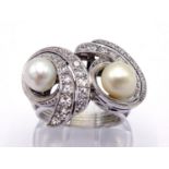 A pearl (untested) and diamond dress ring, set with two off round pearls amid a pave set swirl of