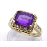 An 18 carat gold, amethyst and diamond dress ring, the central step cut stone 9 x 6.5mm, in a pave