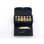 A folding black leather pocket First Aid case with six screw top bottles, five with original labels,