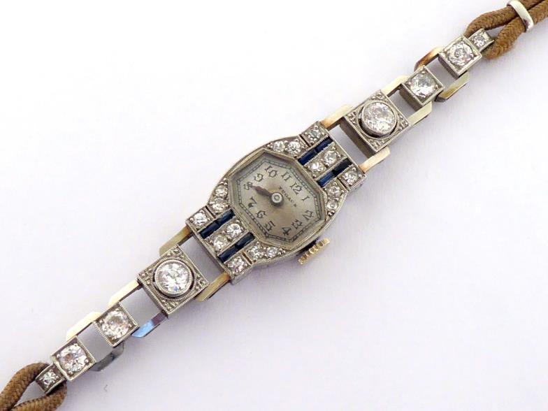An Art Deco platinum, diamond and sapphire cocktail watch, the shaped rectangular bezel set with