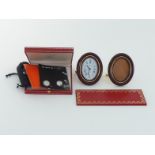 CARTIER, a gilt metal and enamel bedside clock, no.7509 26944, with oval burgundy enamel frame,