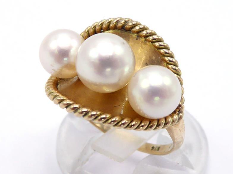 A cultured pearl ring, set with three slightly graduated pearls (the largest 7.3mm), mounted on a