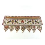 An Indian beadwork portal hanging with pendant lappets, the whole decorated with peacocks, cattle, a