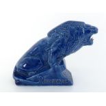 A blue glazed ceramic advertising model of a lion on an inclined plinth, The plinth with inset "