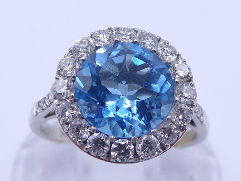 An 18 carat white gold, blue topaz and diamond cluster ring, the central round cut stone 8 x 4. - Image 2 of 5