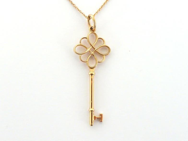 TIFFANY & Co., an 18 carat gold key pendant, signed and hallmarked, 4.5cm long, together with 18