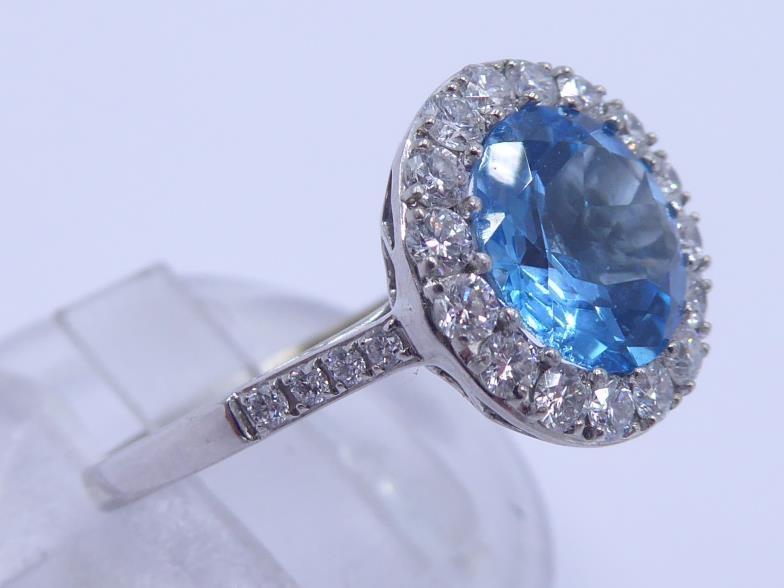 An 18 carat white gold, blue topaz and diamond cluster ring, the central round cut stone 8 x 4. - Image 3 of 5