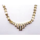 A diamond necklace, the central fringed motif channel set with small brilliant cuts totalling