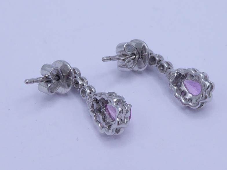 A pair of pink sapphire and diamond earrings, the central pear cut sapphire drop in a surround of - Image 2 of 2