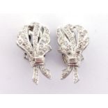 A pair of diamond ear clips, both designed as foliate bouquets, pave set overall with single cuts, a