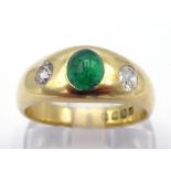 An Edwardian 18 carat gold, emerald and diamond ring, the rub over set stones comprising a central