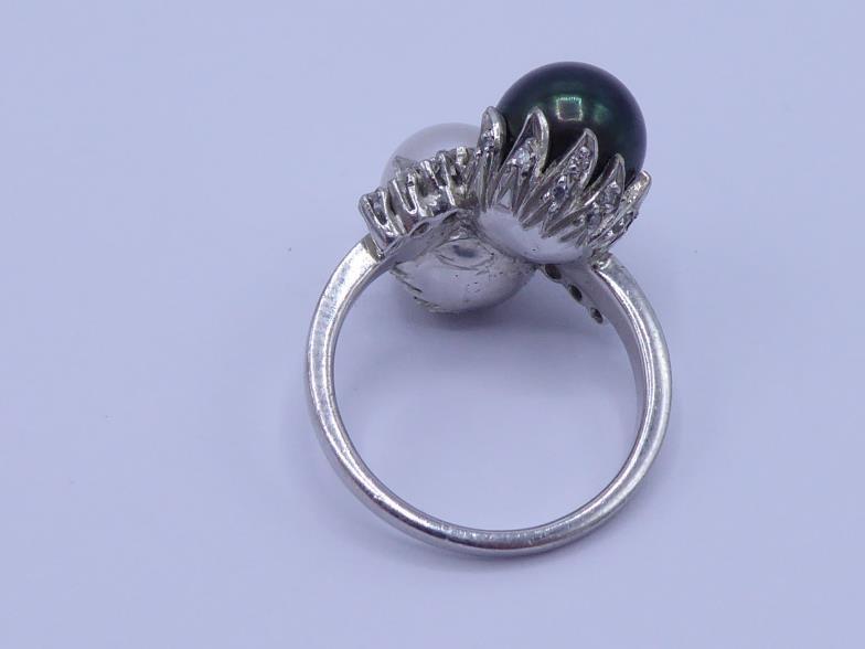 A two colour pearl and diamond ring, the cross over mount with an 8.2mm black and white pearl, a - Image 3 of 3