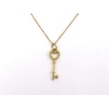 TIFFANY & Co., an 18 carat gold key pendant, 2.6cm long, signed and fully hallmarked, to a fine link