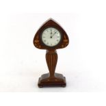 A solid mahogany Art Nouveau mantel clock shaped as a stylised plant stem and bud on a spreading