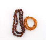 An amber bead necklace, composed of uniform oval beads, each 20.8mm long, to a screw barrel clasp,